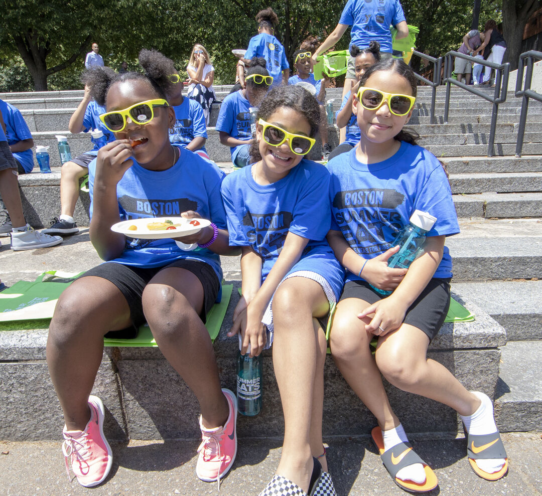 Three girls enjoy lunch at a Summer Eats meal site in Boston.