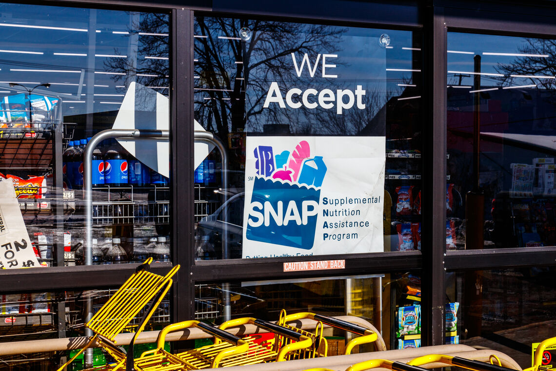Convenient store displays We Accept SNAP Here sign on door
